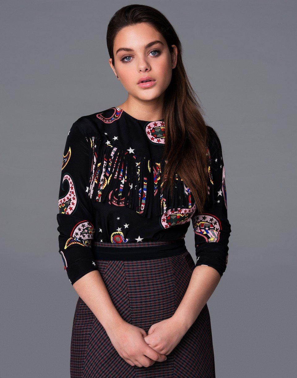 Odeya Rush posing with her hands locked in front of her